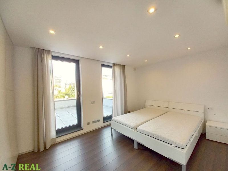 A bedroom with a bed and a wooden decor floor in a 4-room apartment.