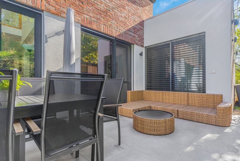 Family house with a terrace, rattan seating, and a dining table.