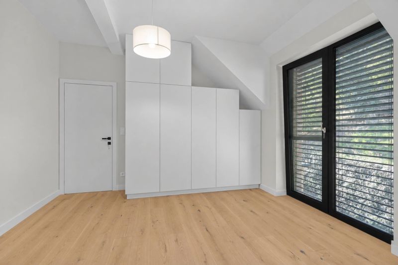 White built-in wardrobe and wooden decor flooring in a family house.