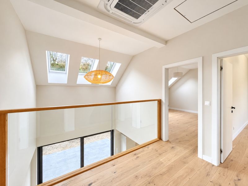 Attic space with glass railing and wooden decor flooring, family house.