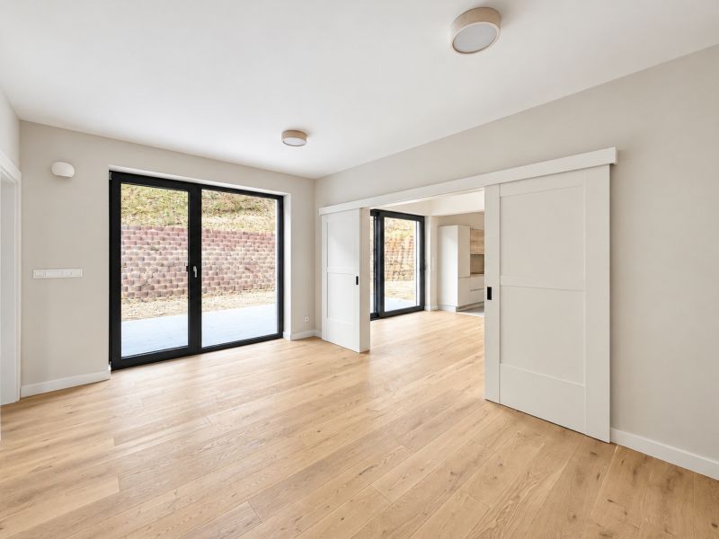 A family house with large sliding doors and a floor with a wood decor.