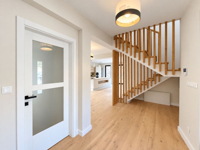 A family house with a wooden decor floor, staircase, and glass doors.
