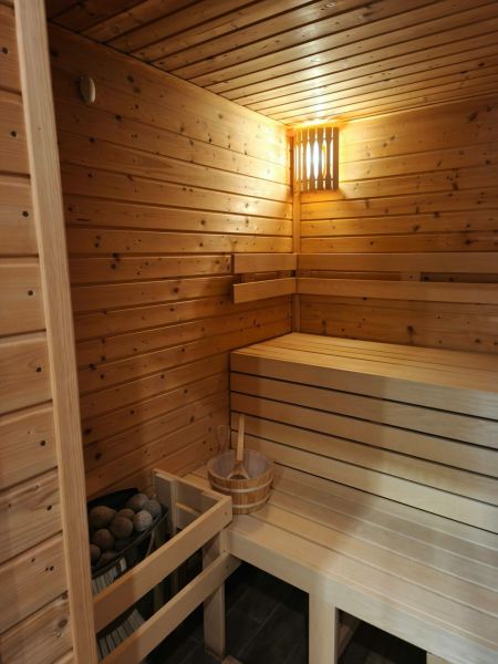 The interior of a sauna in a family house with wooden paneling and benches.
