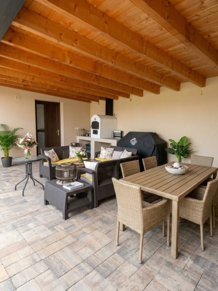 A covered terrace with comfortable rattan furniture in a family house.