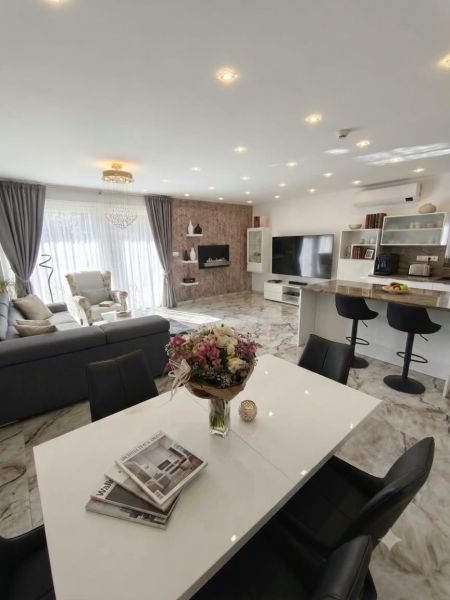 Living room in a family house with spacious seating, dining table, and decorative elements.