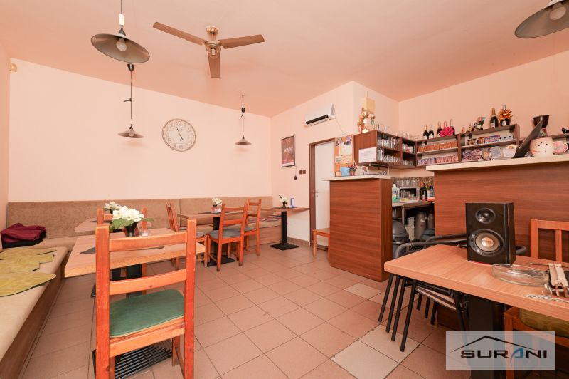 Commercial premises with wooden tables, wall clocks, and a bar counter.