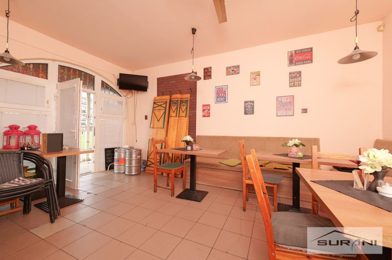 Interior of commercial spaces with furniture, wall decorations, and beer kegs.