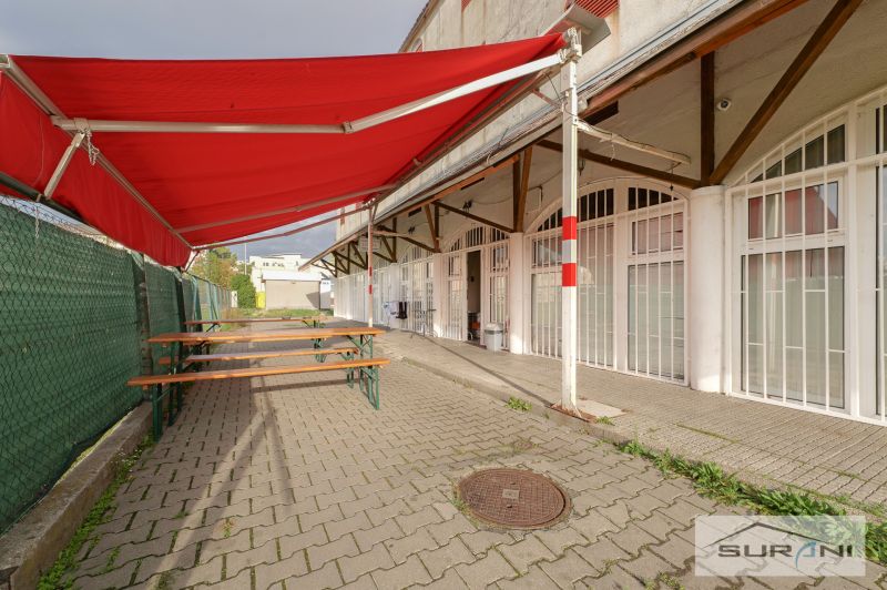 The exterior of commercial premises with a red awning on Korytnická Street, Bratislava - Podunajské Biskupice.