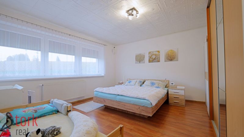 A bedroom in a 4-room apartment with a double bed and a floor with a wooden decor.
