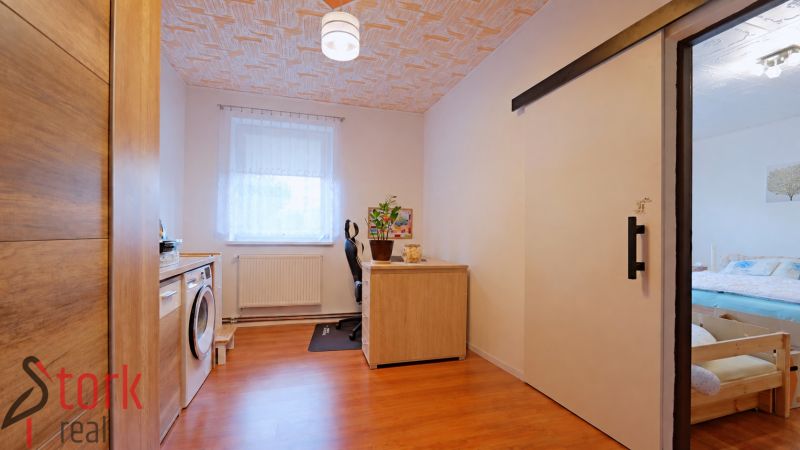 Home office and laundry room in a 4-room apartment with wood-patterned flooring.