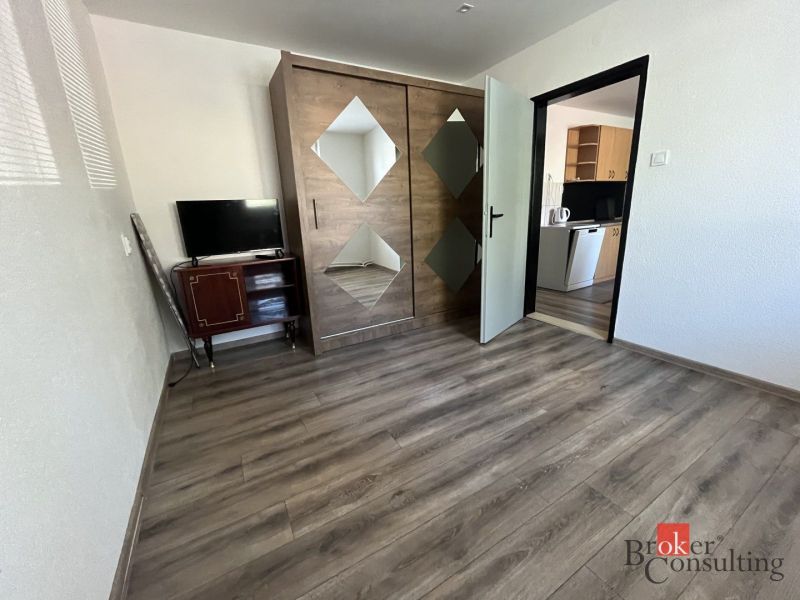 A room in a 4-room apartment with a wooden decor floor and a built-in wardrobe.