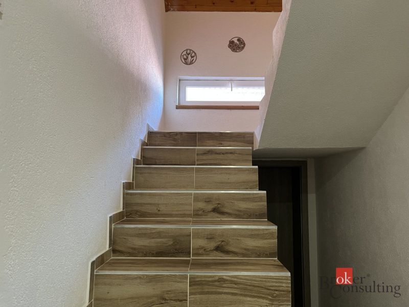 A staircase with wooden decor steps in a 4-room apartment.