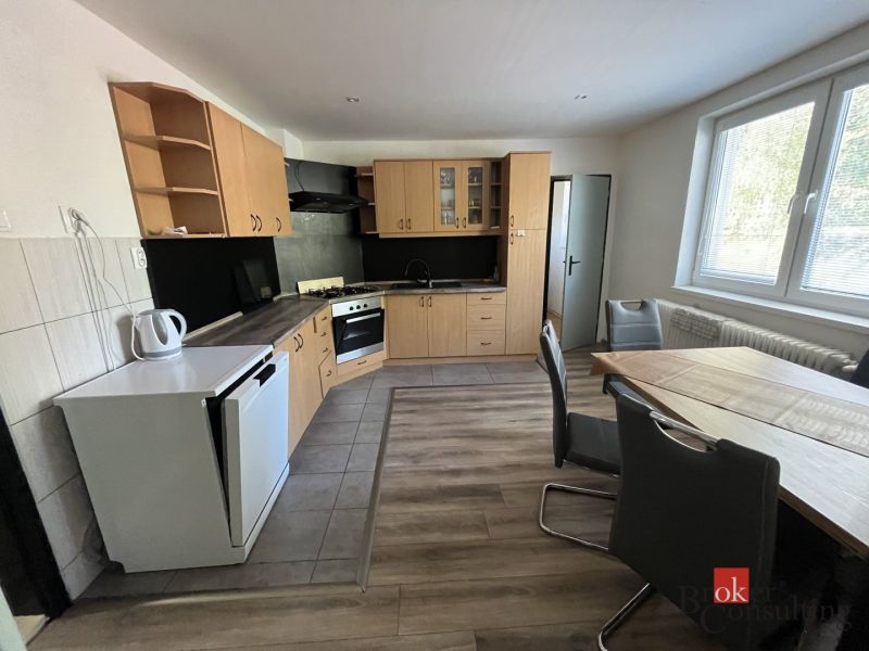 A kitchen in a 4-room apartment with a corner unit and a floor with a wooden decor.