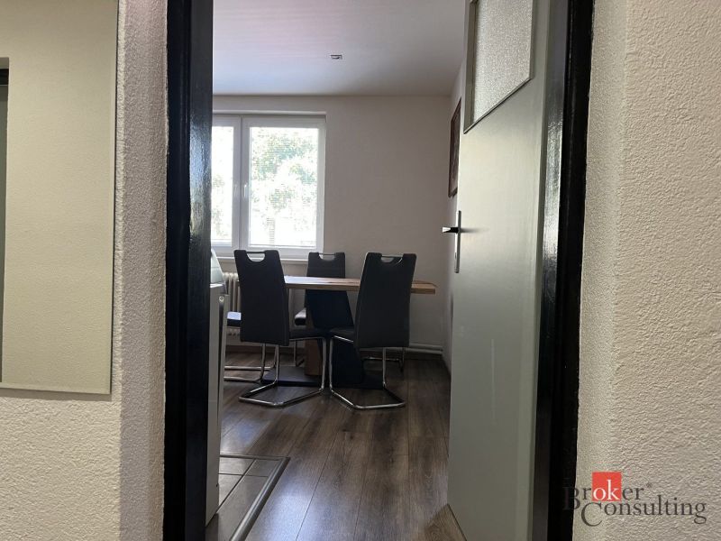 Wooden floor decor in the dining room of a 4-room apartment with a dining table and chairs.