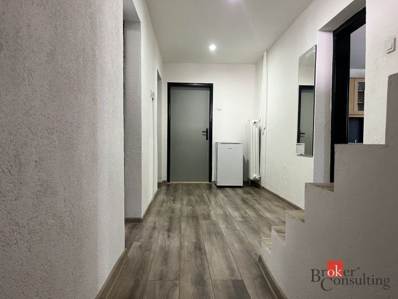 Entrance hallway in a 4-room apartment with a wood-patterned floor and a staircase.