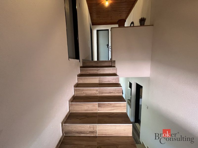 A staircase with a wooden floor and white walls in a 4-room apartment.