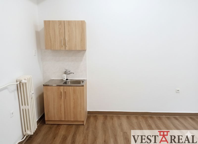 Offices with a cabinet and sink, floor with wood decor.