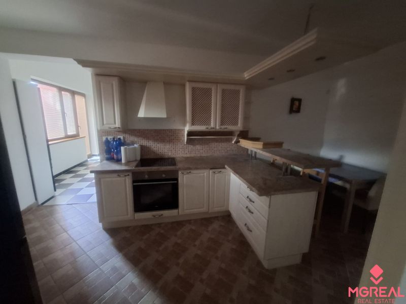 A kitchen in a family house with a kitchen unit, appliances, and a dining area.