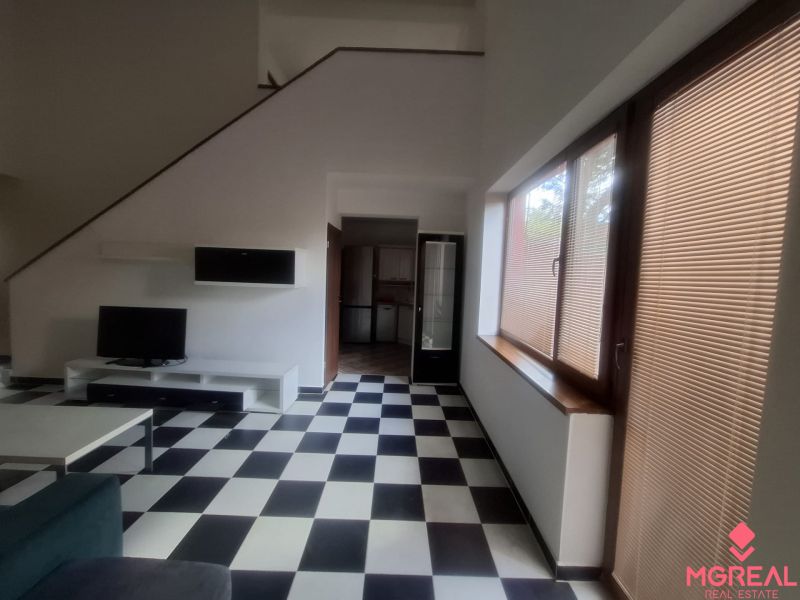 Living room in a family house with black and white flooring and large windows.