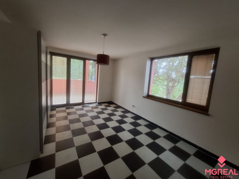 A room in a family house with black and white tiles and large windows.
