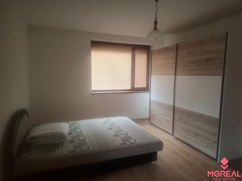 A bedroom in a family house with a wooden decor floor and a large wardrobe.