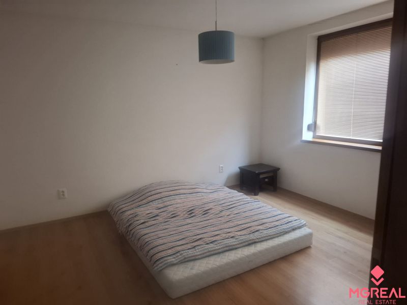 A room with a mattress on the floor with wooden decor in a family house.