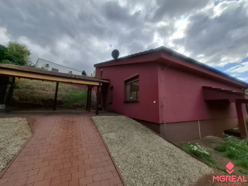 A family house on Chmeľová dolina in Zobor with a red facade and a paved walkway.