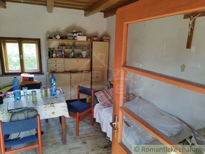 Interior of a cabin with a bed, table, chairs, and a floor with a wooden decor.