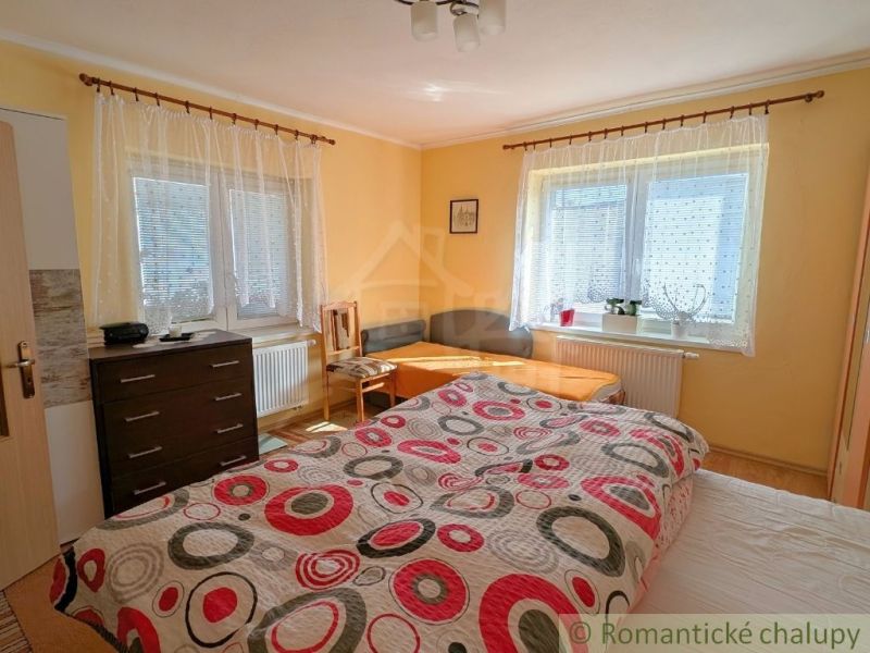 A bedroom in a family house with decorative bedding and light-colored walls.
