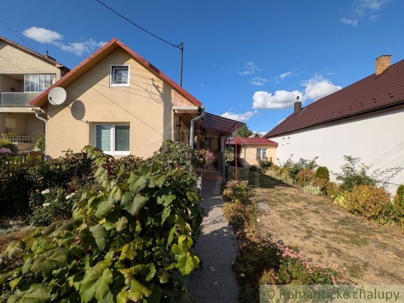 A family house in Cabov with a landscaped garden and a red roof under a blue sky.