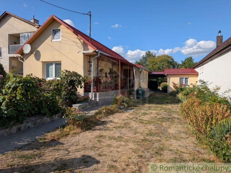 A family house in Cabov with a red roof, a front garden, and a paved walkway.
