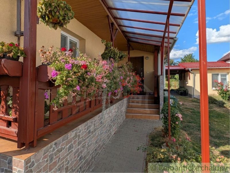 A family house in Cabov with a front porch surrounded by flowers and interlocking paving.