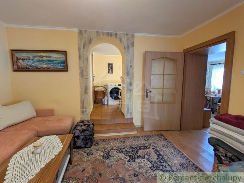 Living room in a family house with an arched passage and a wooden decor floor.