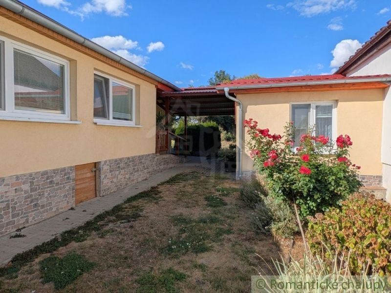 A family house in Cabov with rose bushes and a paved walkway.