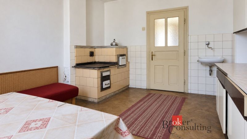 A kitchen in a family house with a traditional stove and a wooden decor floor.
