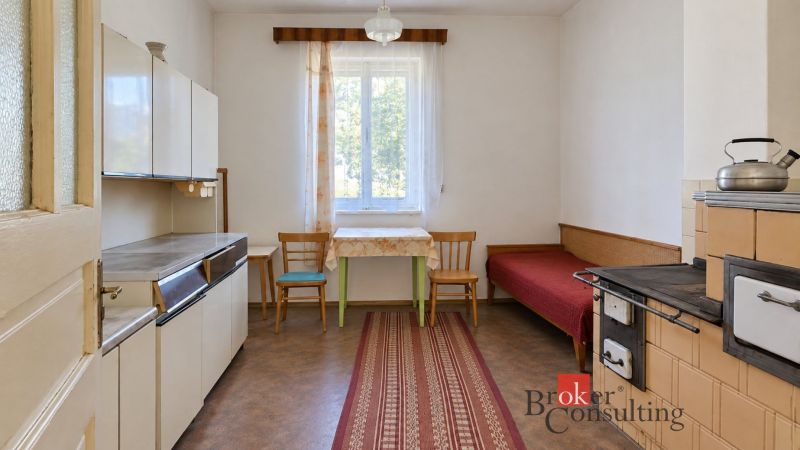 A kitchen with a stylish stove, simple furniture, and a wooden decor floor in a family house.