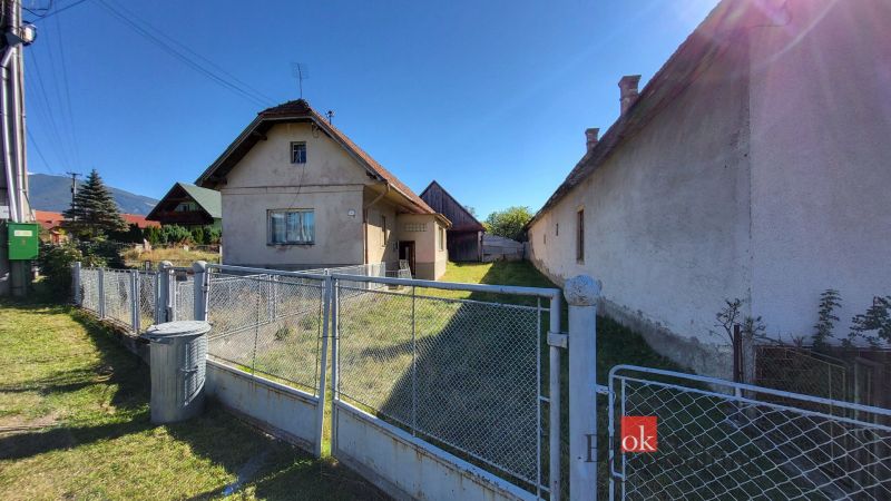 A family house in the town of Žiar with a yard, fence, and surrounding greenery.