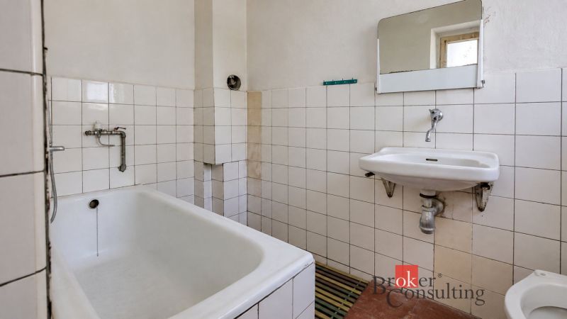 A bathroom in a family house with an older bathtub and sink.