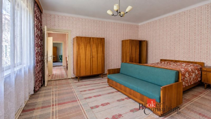 A room in a family house with retro furniture and patterned wallpaper.