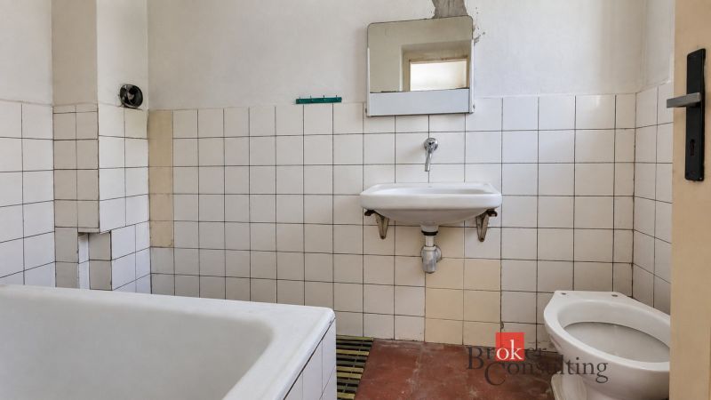 A bathroom in a family house with white tiles and simple sanitary ware.