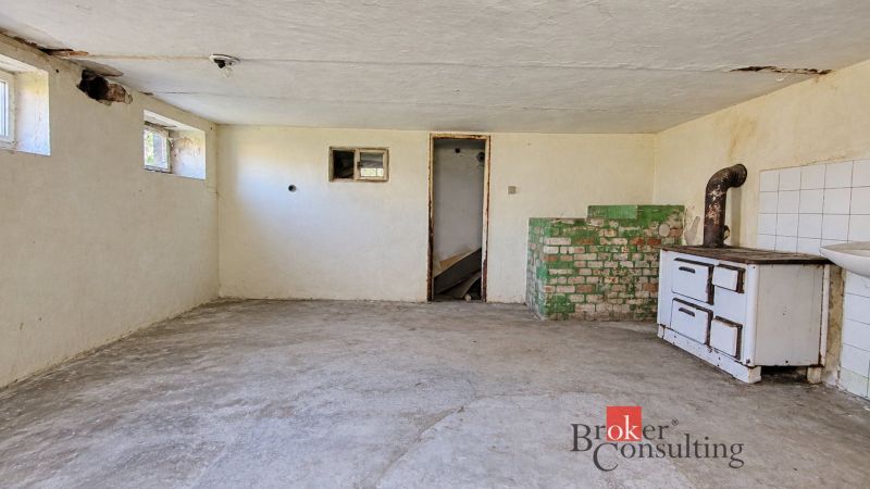 Basement of a family house with a tiled stove and a sink, near Žiar.