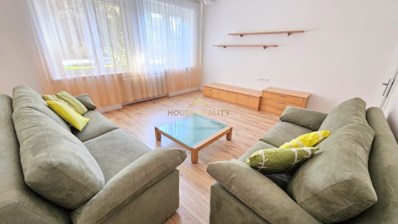 Living room in a two-room apartment with two sofas and a wooden decor floor.