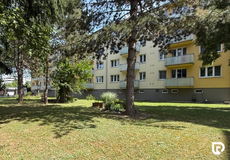 An apartment building with balconies surrounded by greenery on Pred poľom in Trenčín.