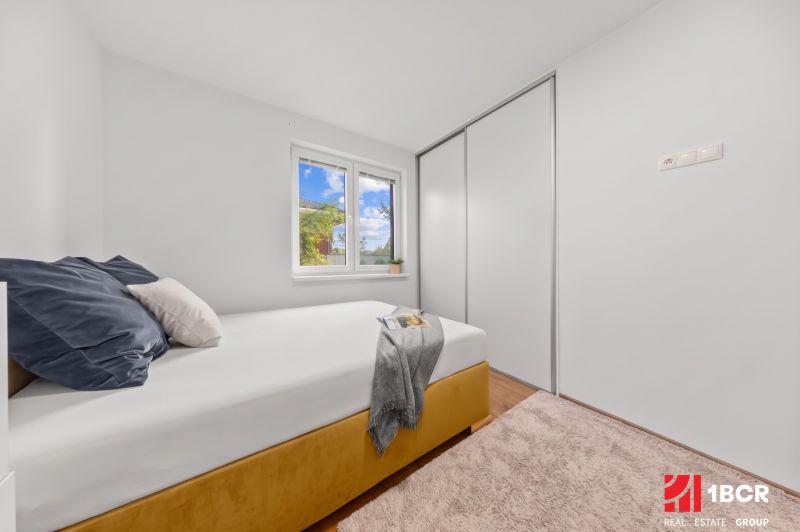 Bedroom in a 3-room apartment with a bed, wardrobe, and laminate flooring.