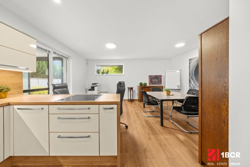 A kitchen with an island and a wooden decor floor in a 3-room apartment.