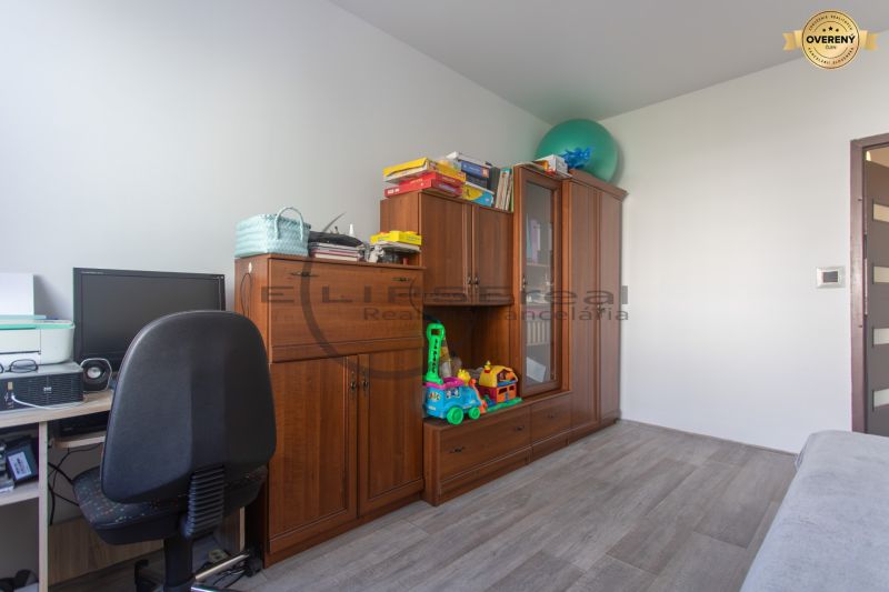A home office with a computer, cabinets, and a wooden decor floor in a 3-room apartment.
