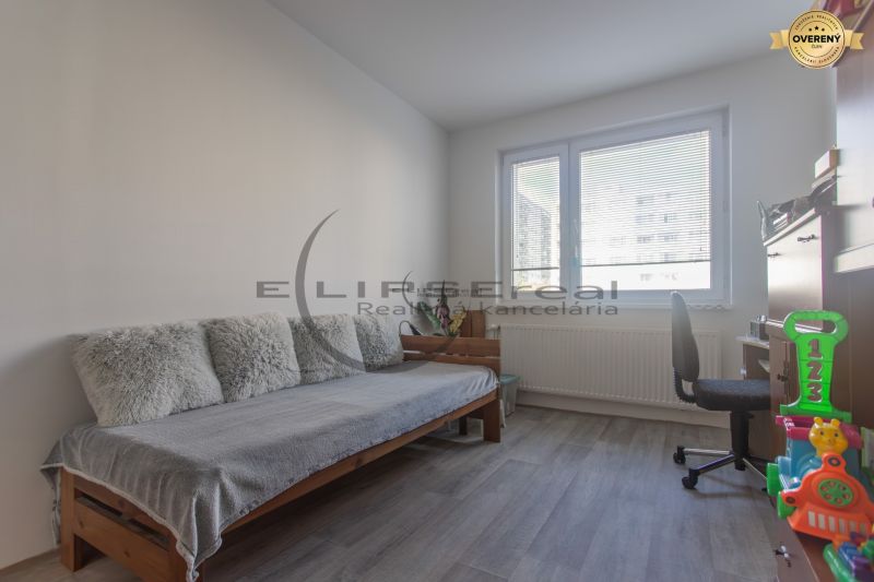 Children's room in a 3-room apartment with a sofa, desk, and toys.