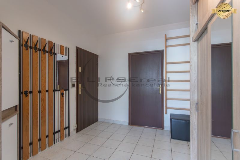 Hallway with a coat rack wall, mirror, and tiles in a 3-room apartment.