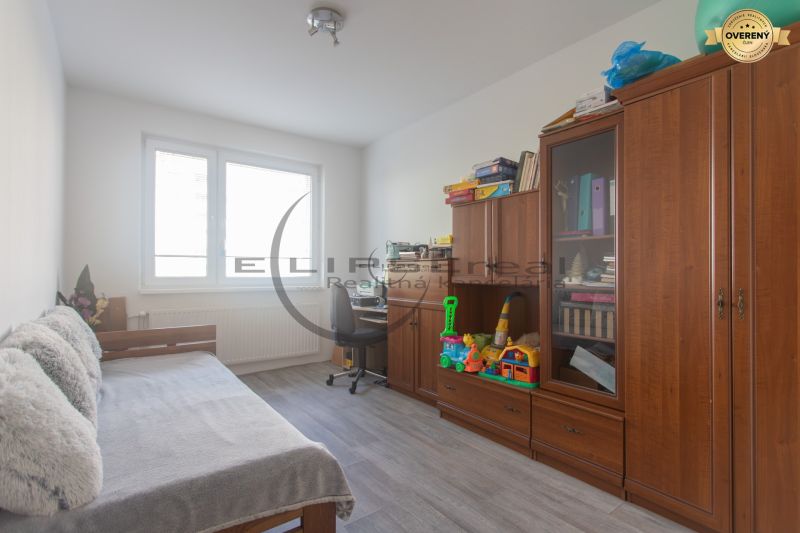 Children's room in a three-room apartment, armchair, sofa, shelf with toys and books.