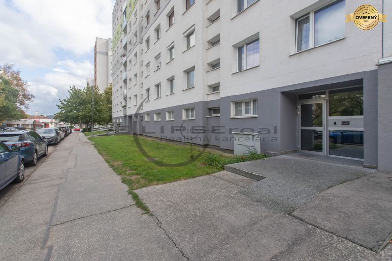 Apartment building on Eisnerova Street in Bratislava - Devínska Nová Ves surrounded by a parking lot.